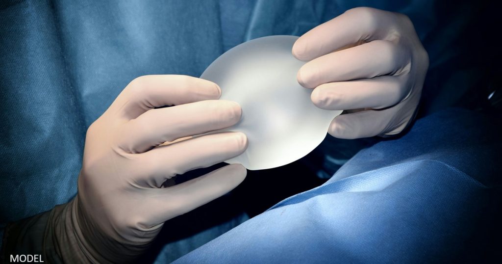 Surgeon holding a breast implant
